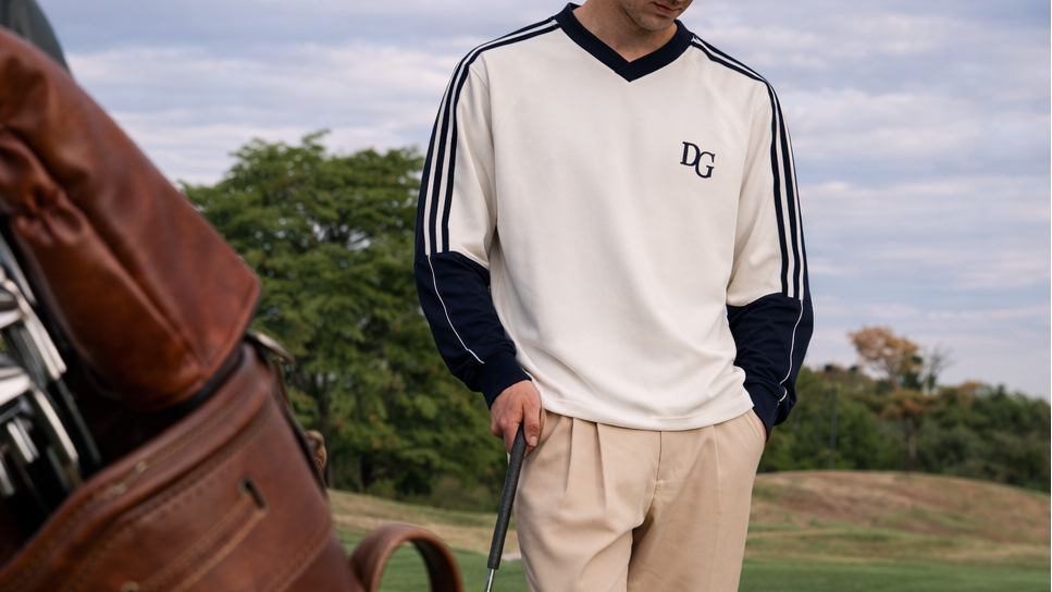 Person on a golf course holding a club with a golf bag nearby